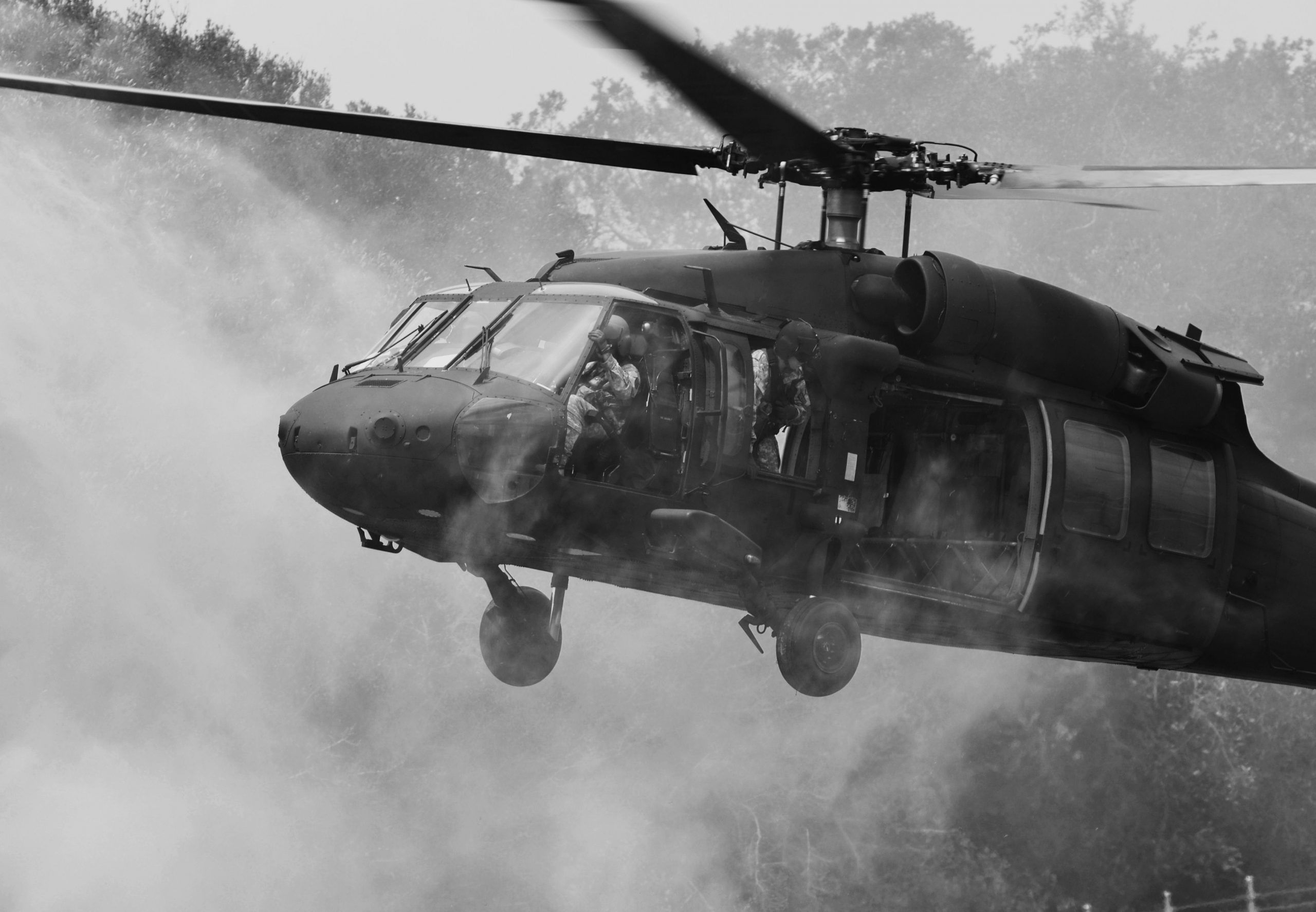 A Sikorsky UH-60 Black Hawk kicks up dust as it lands.